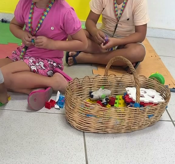 Crianças autistas brincando com o cordão de quebra-cabeça
